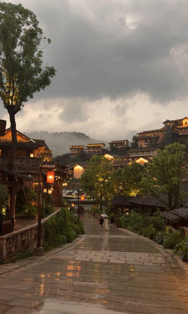 Lanterns glowing over a hillside town at dusk