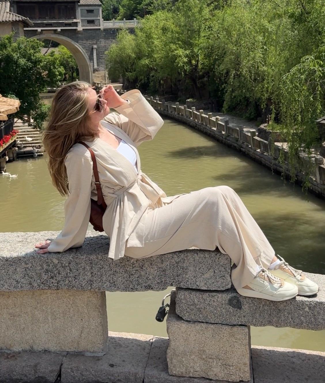Sitting on a stone bridge above a canal in Gubei Water Town